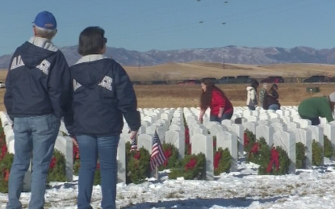 ‘Their service keeps us free,’ volunteers place wreaths on the graves of fallen heroes as part of Wreaths Across America - Featured Image - Older couple honoring veteran graves